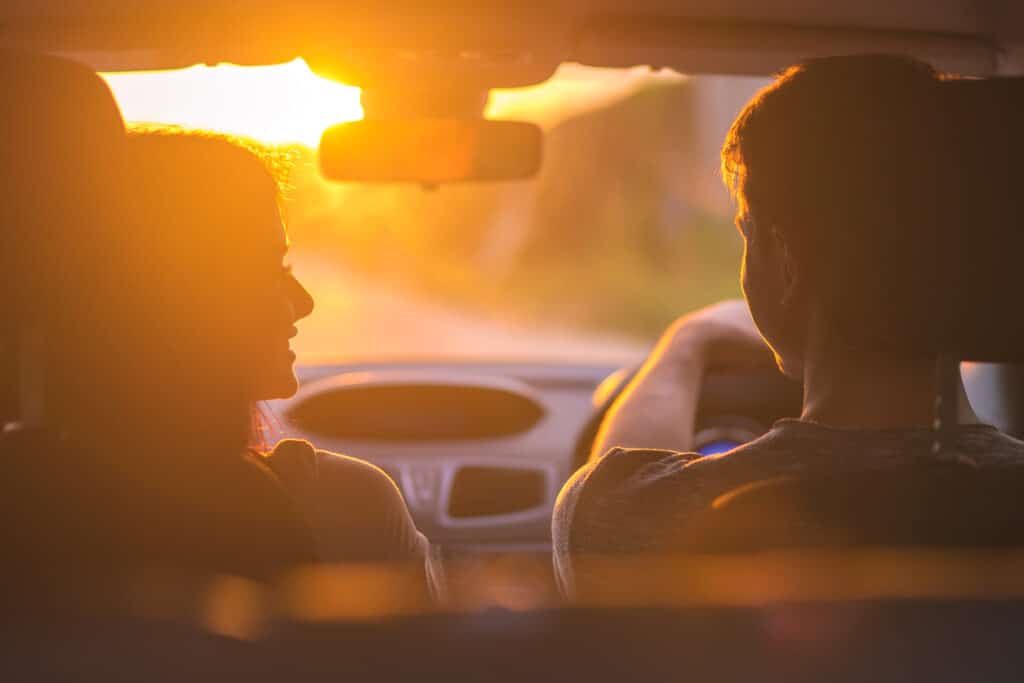 couple driving at evening sunset
