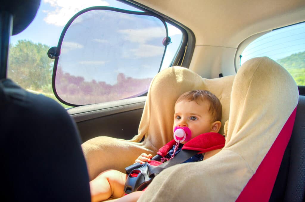 baby in baby seat in back of car